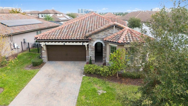 mediterranean / spanish-style home featuring a garage and a front lawn