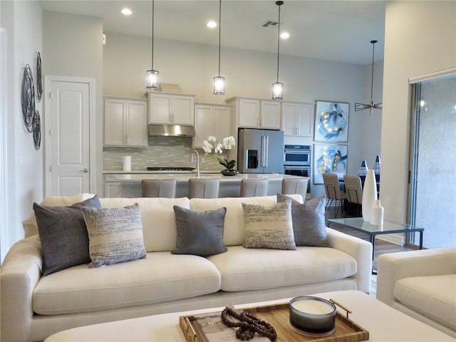 living room with recessed lighting, visible vents, and a high ceiling