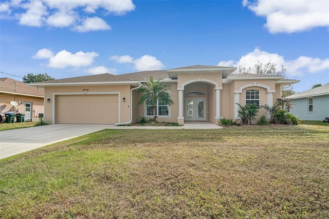 view of front facade with a garage, a front yard, and french doors