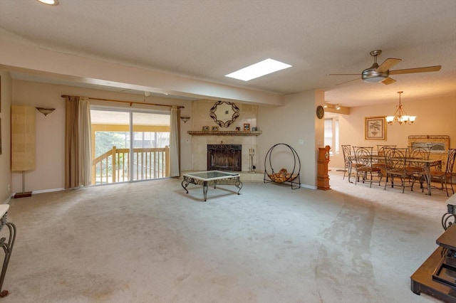 carpeted living room featuring ceiling fan, a textured ceiling, and a tile fireplace