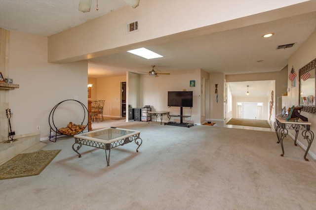 carpeted living room with ceiling fan and a textured ceiling