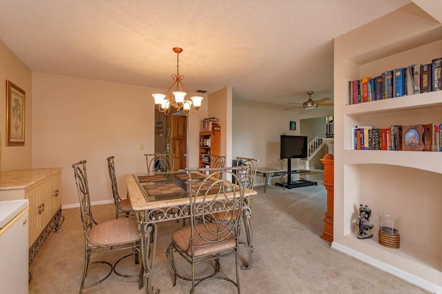 carpeted dining space with ceiling fan with notable chandelier and built in features