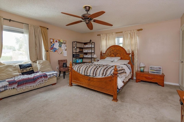 carpeted bedroom with ceiling fan and a textured ceiling