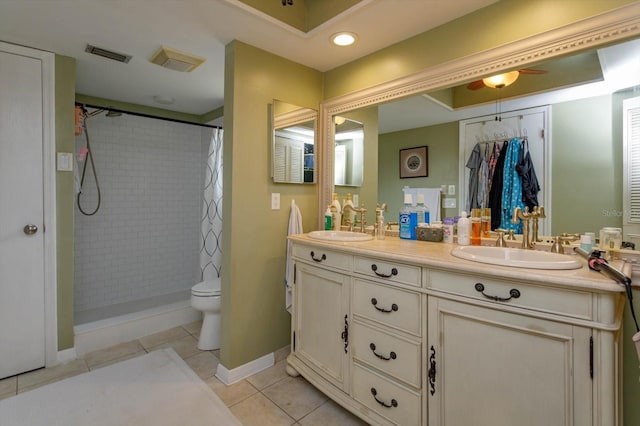 bathroom featuring toilet, tile patterned flooring, vanity, and walk in shower