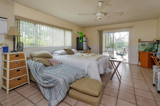 tiled bedroom featuring ceiling fan, access to exterior, and a textured ceiling