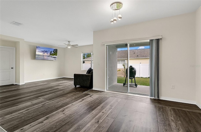 interior space featuring a ceiling fan, wood finished floors, visible vents, and baseboards