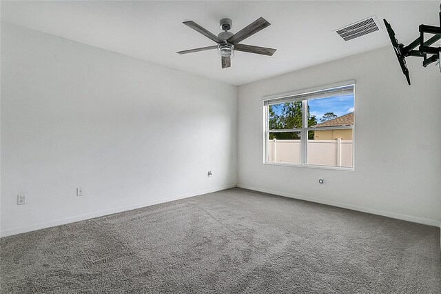 spare room with visible vents, a ceiling fan, baseboards, and carpet floors