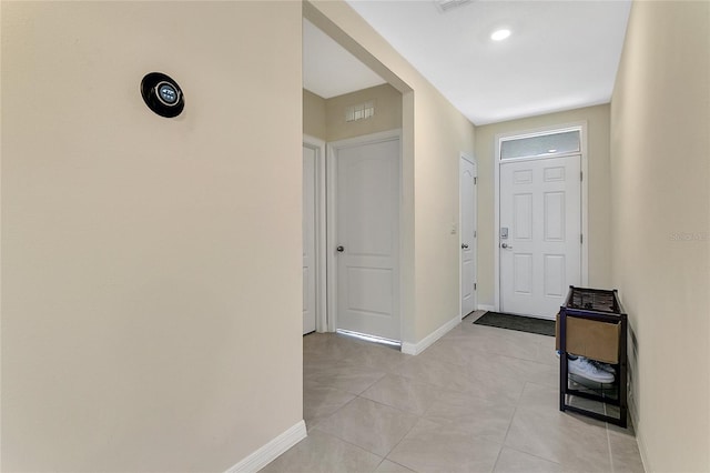 foyer entrance with light tile patterned floors, visible vents, and baseboards