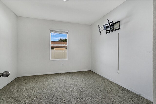 unfurnished room with carpet and baseboards