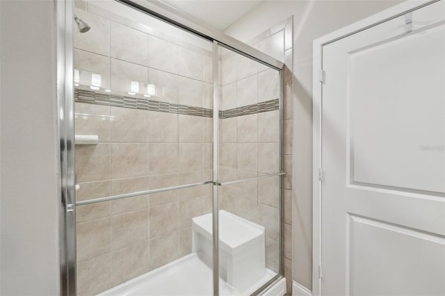 bathroom with a shower with door