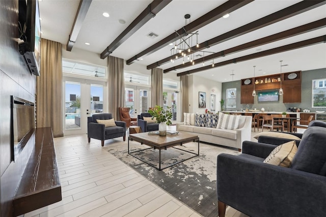 living room with beam ceiling, french doors, and plenty of natural light