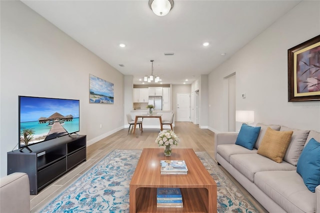 living room featuring a notable chandelier and light hardwood / wood-style floors