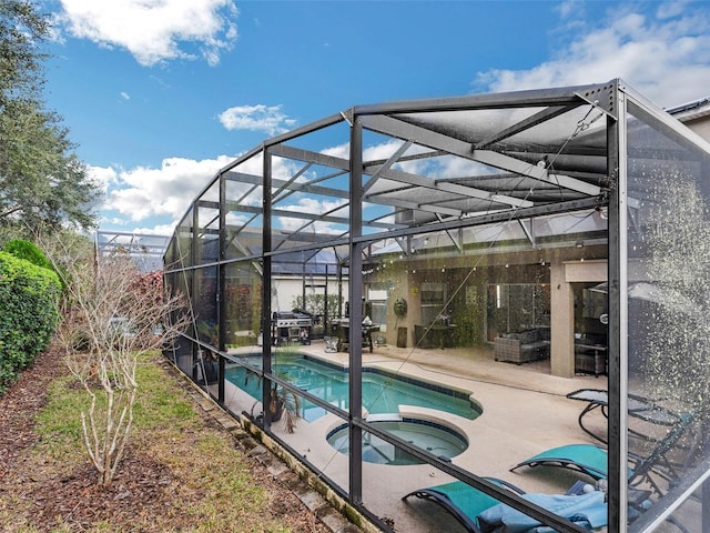 view of pool featuring an in ground hot tub, a patio, and a lanai