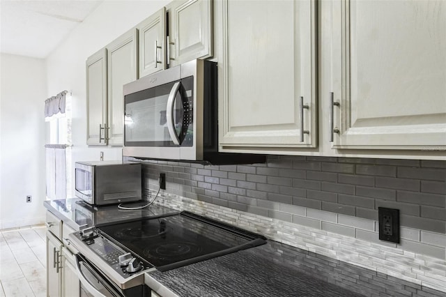 kitchen with backsplash, light wood-type flooring, and stainless steel appliances