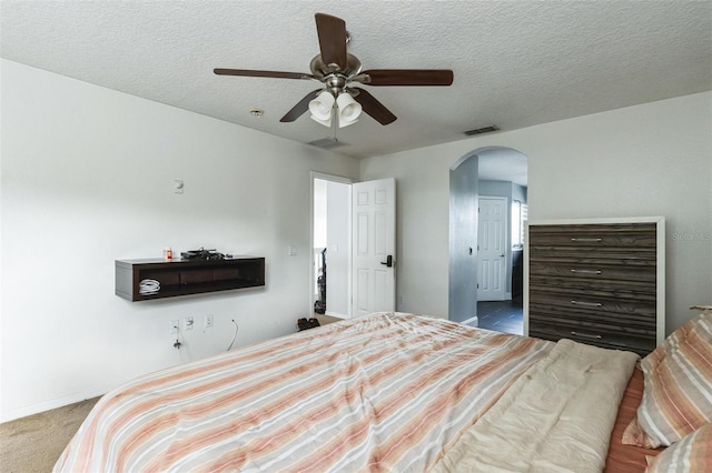 bedroom featuring ceiling fan, carpet floors, and a textured ceiling