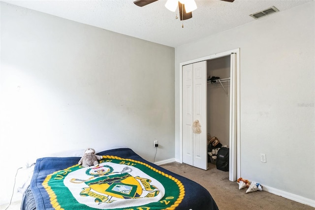 carpeted bedroom featuring a textured ceiling, a closet, and ceiling fan