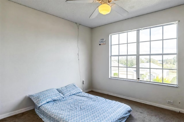 bedroom with multiple windows, ceiling fan, and a textured ceiling