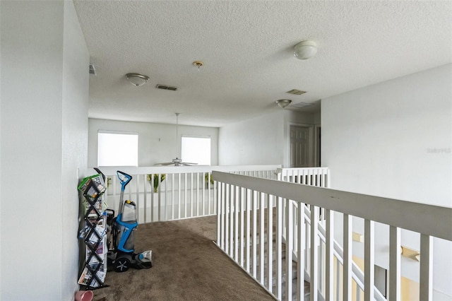 corridor featuring carpet and a textured ceiling