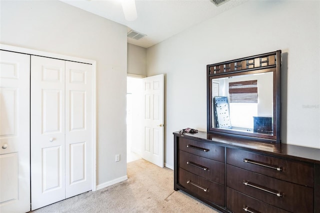 bedroom featuring ceiling fan, light colored carpet, and a closet