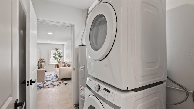 laundry area featuring light tile patterned floors and stacked washer / dryer