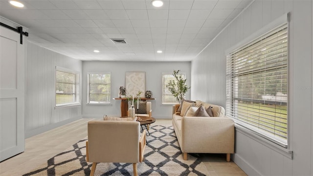 living room with a barn door and a wealth of natural light