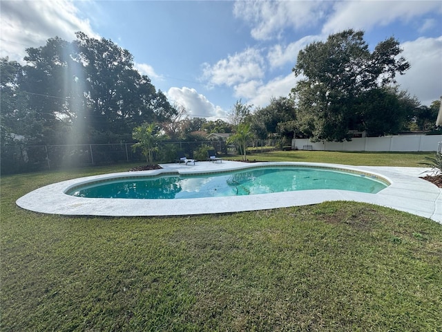 view of swimming pool featuring a yard