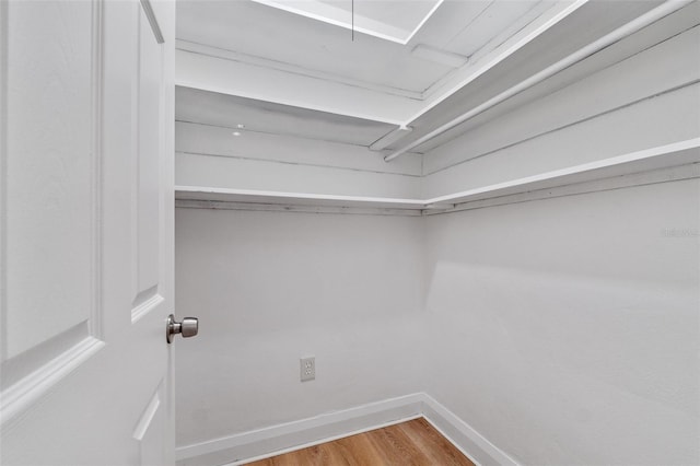 walk in closet with wood finished floors