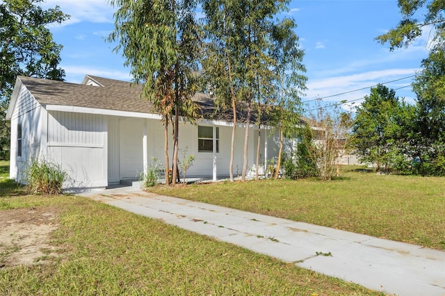 rear view of house with roof with shingles and a yard