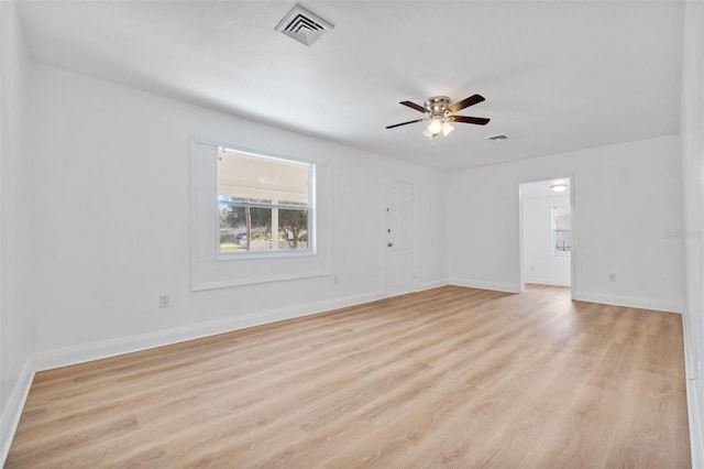 spare room with light wood-style flooring, baseboards, ceiling fan, and visible vents