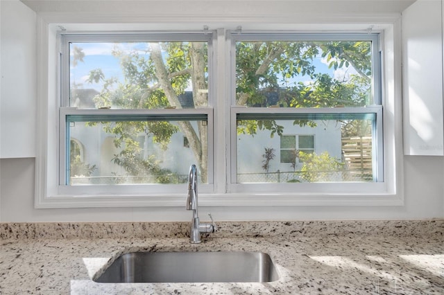 interior details featuring light stone countertops and a sink