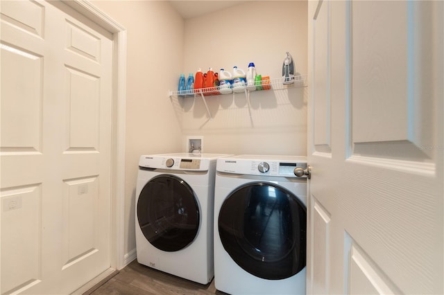 laundry area with washer and dryer and dark wood-type flooring