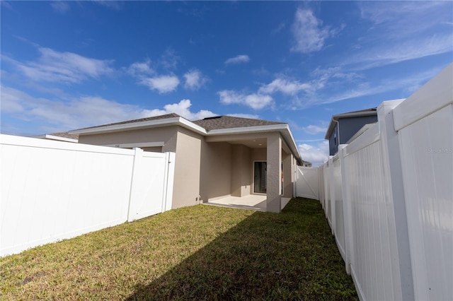 back of property featuring a yard and a patio area