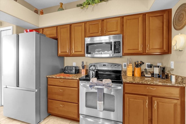 kitchen featuring stone counters, light tile patterned floors, and stainless steel appliances