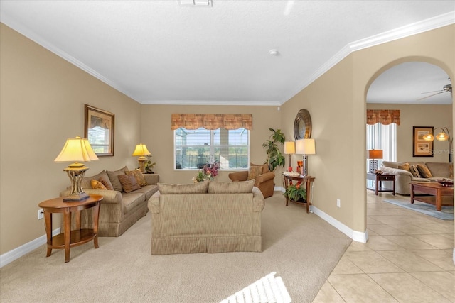 living room with crown molding, ceiling fan, and light carpet