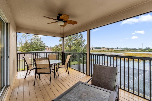 sunroom / solarium with ceiling fan, a water view, and plenty of natural light