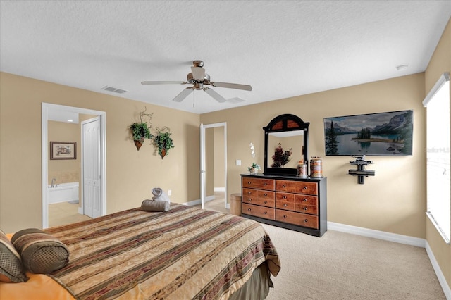 carpeted bedroom with ensuite bath, ceiling fan, and a textured ceiling