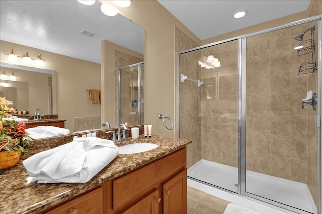 bathroom featuring tile patterned flooring, vanity, and walk in shower