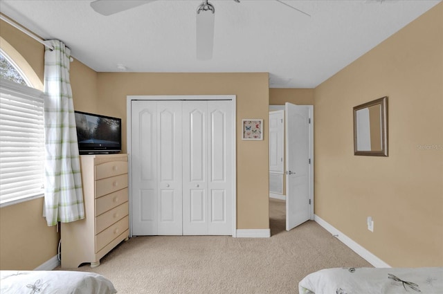 carpeted bedroom with a closet and ceiling fan