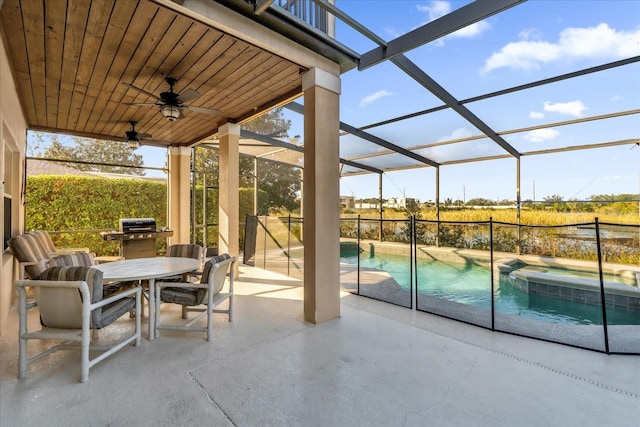 view of patio with ceiling fan, a swimming pool with hot tub, and a lanai