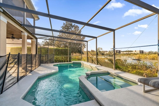 view of swimming pool with glass enclosure, a water view, and an in ground hot tub