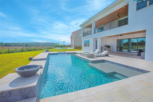 view of swimming pool with a fenced backyard, a yard, a patio area, an in ground hot tub, and a ceiling fan