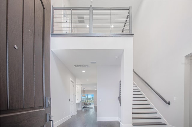 entryway featuring visible vents, wood finished floors, recessed lighting, baseboards, and stairs