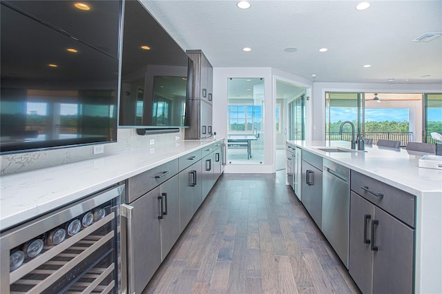 kitchen with visible vents, beverage cooler, a sink, dark wood finished floors, and dishwasher