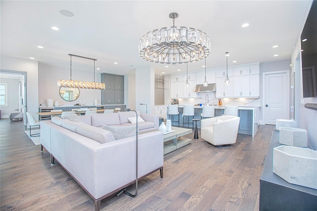 living area with recessed lighting, an inviting chandelier, and dark wood-style flooring