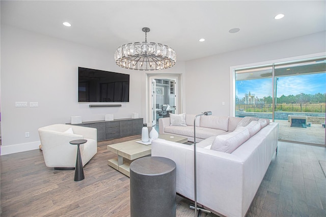 living room featuring a notable chandelier, recessed lighting, wood finished floors, and baseboards