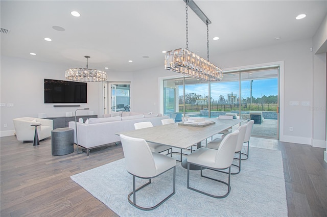 dining area featuring wood finished floors, baseboards, visible vents, recessed lighting, and a notable chandelier