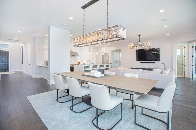 dining room featuring dark wood-type flooring, a notable chandelier, recessed lighting, and baseboards