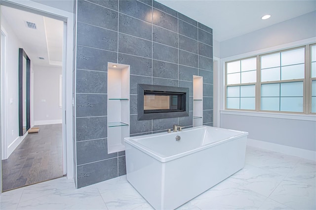 bathroom featuring a freestanding tub, visible vents, marble finish floor, recessed lighting, and a fireplace