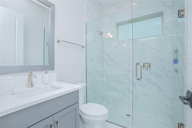 full bath with vanity, a shower stall, and toilet