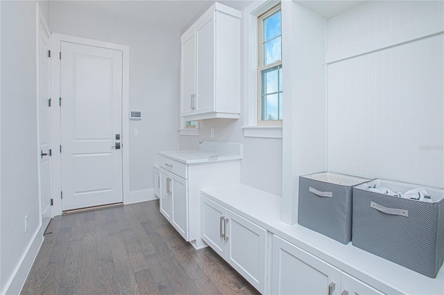 mudroom with dark wood-style floors and baseboards